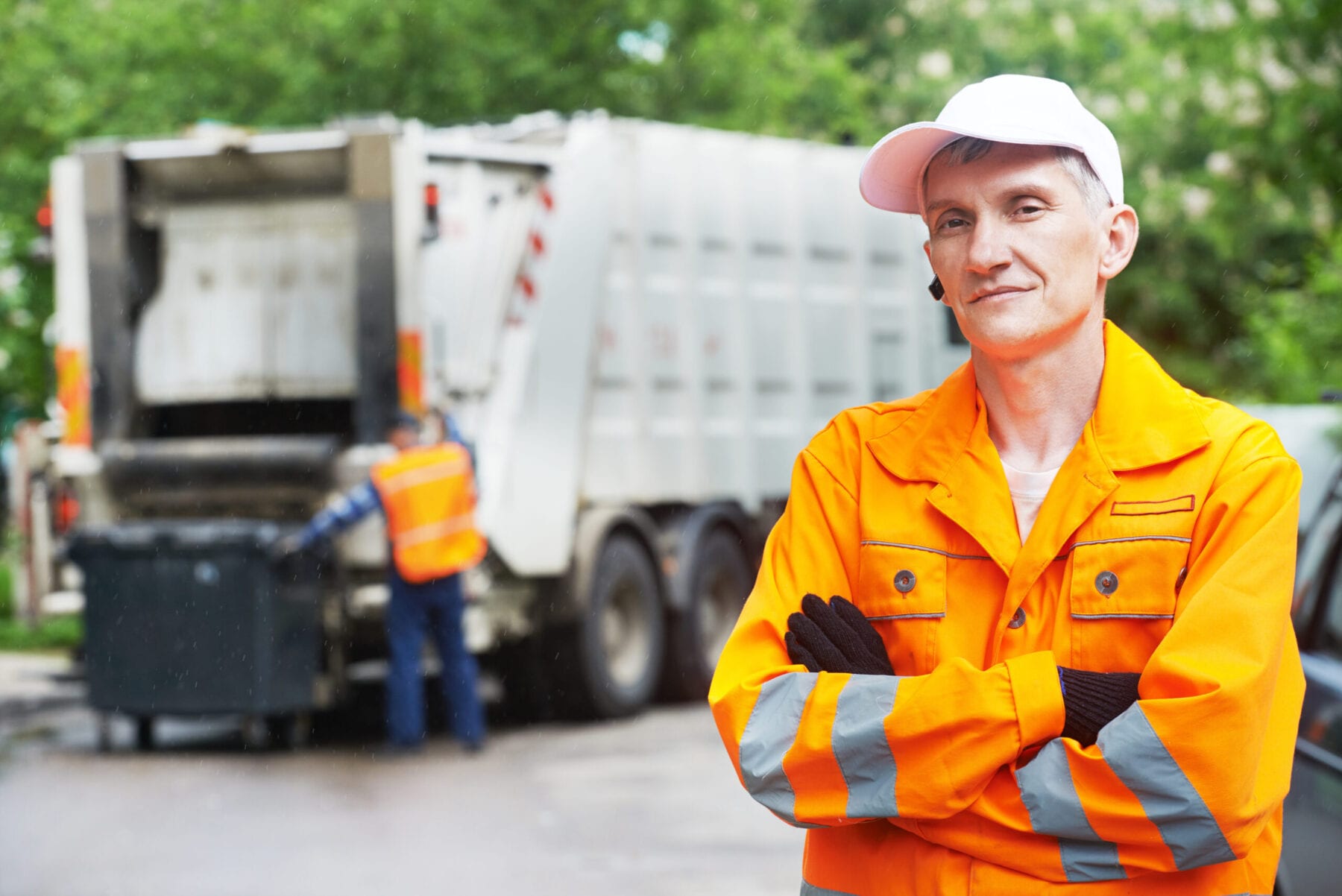 Portrait of municipal worker recycling garbage collector truck loading waste and trash bin